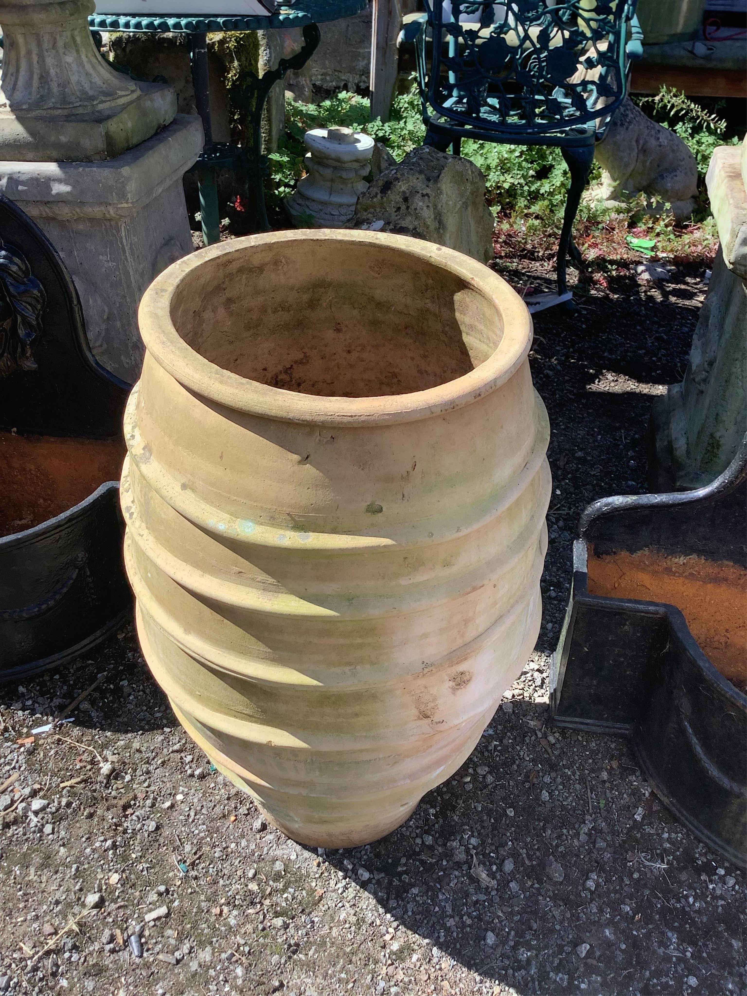 A Greek style earthenware oil jar, height 70cm. Condition - fair